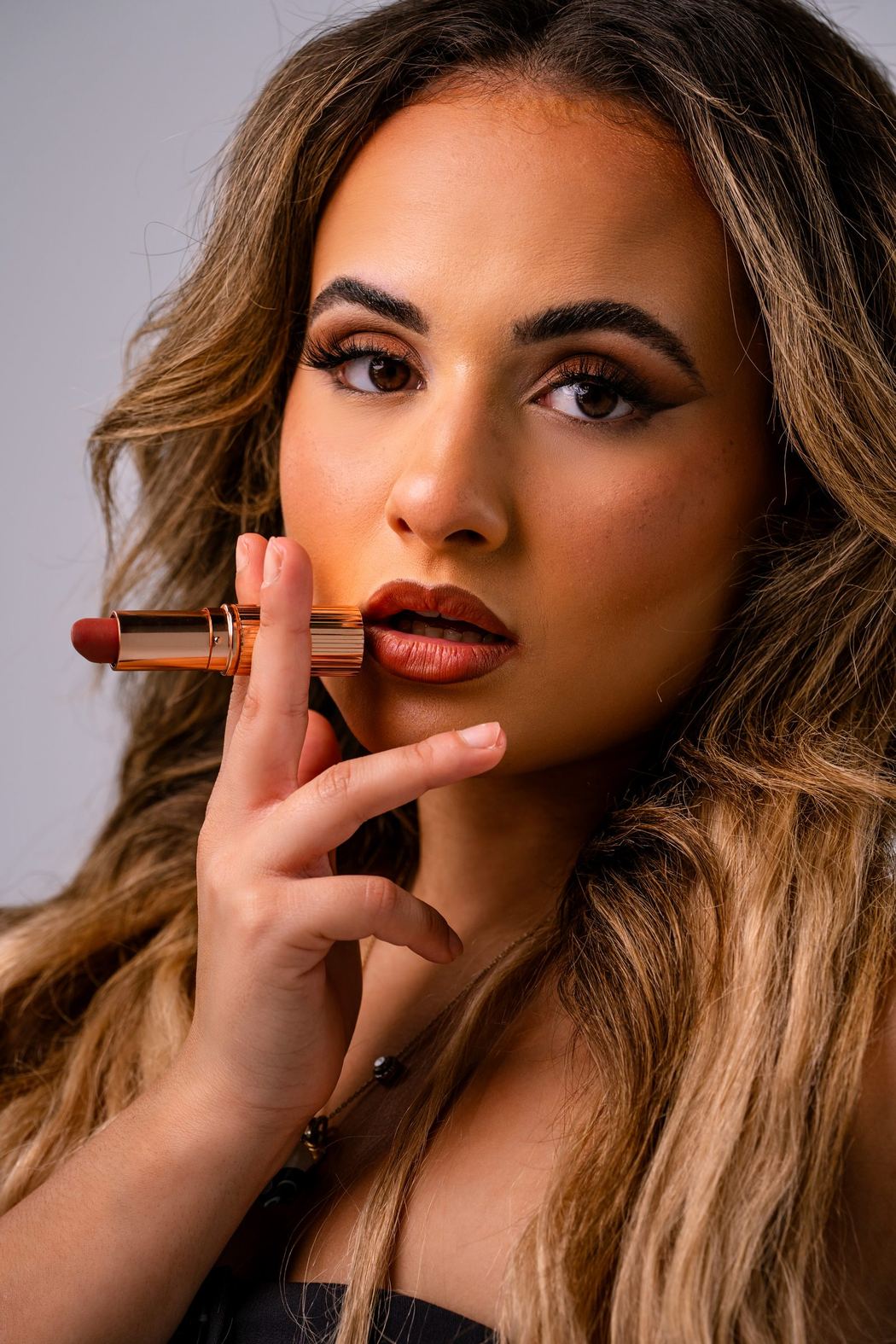 Makeup artist holding a lipstick, close portrait