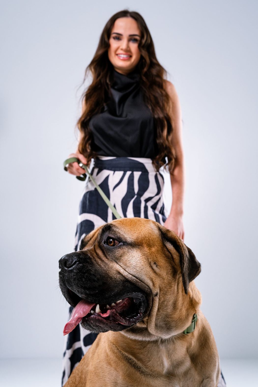 Woman in a black and white outfit with a large dog