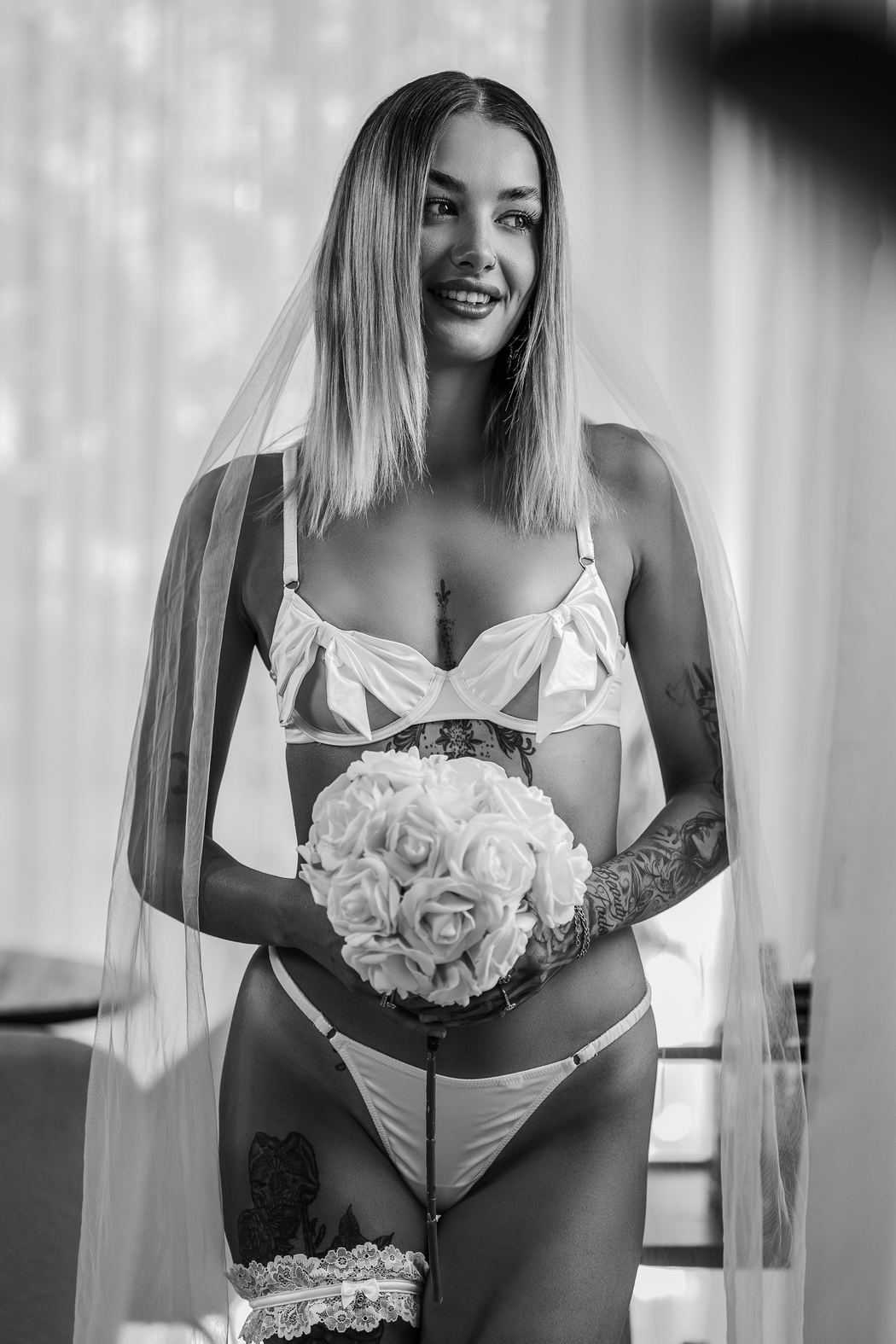 Black and white portrait of a bride laughing with a bouquet