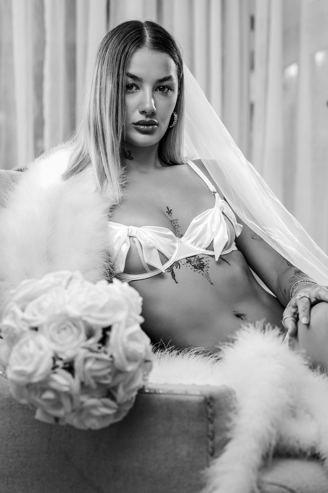 Black and white bride on a sofa with feathers and a bouquet