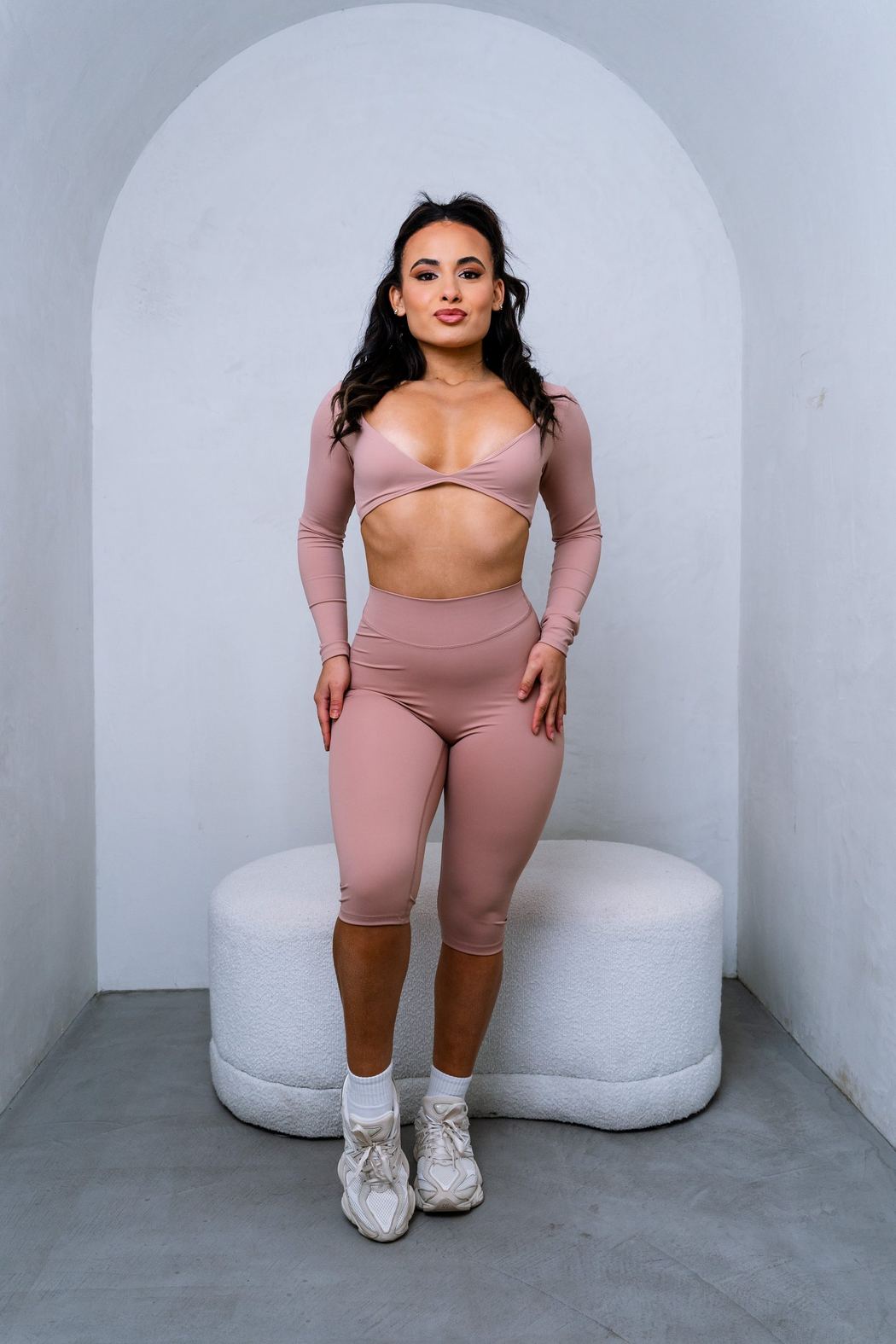 Woman in dusty-pink activewear in an arched alcove
