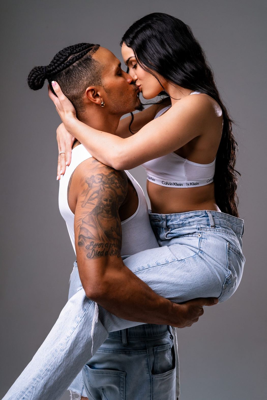 Couple embracing in a studio, jeans and white tops