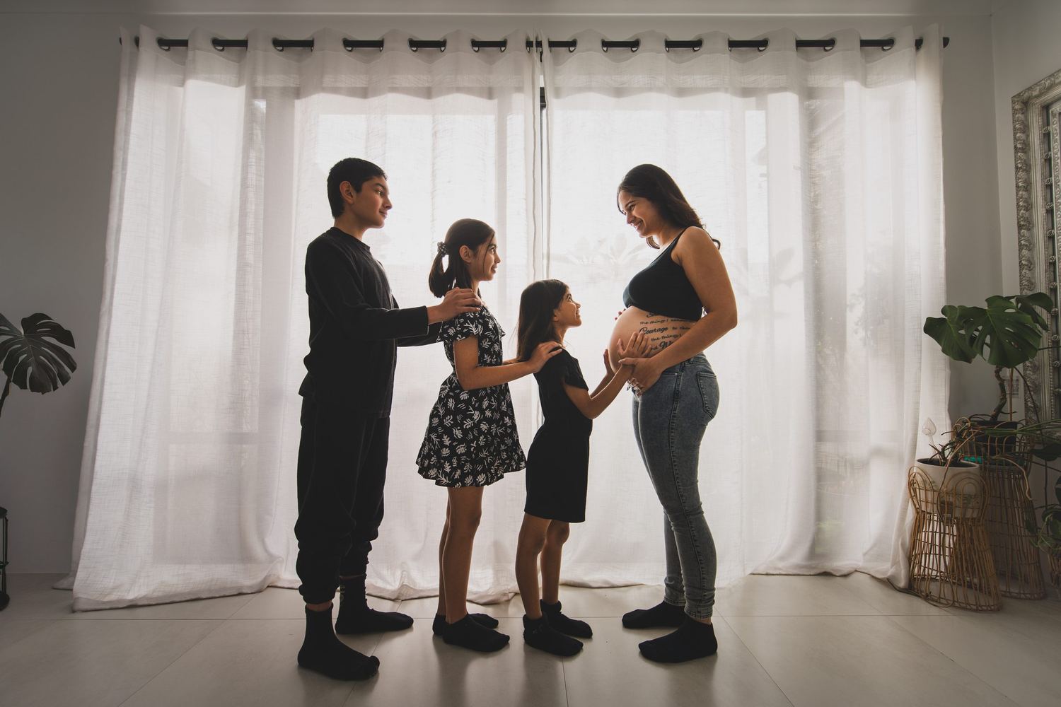 Family of four silhouetted at a window